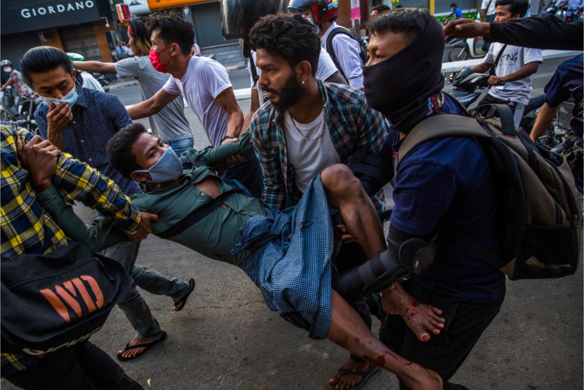 Injured man carried by protesters © Panos Pictures